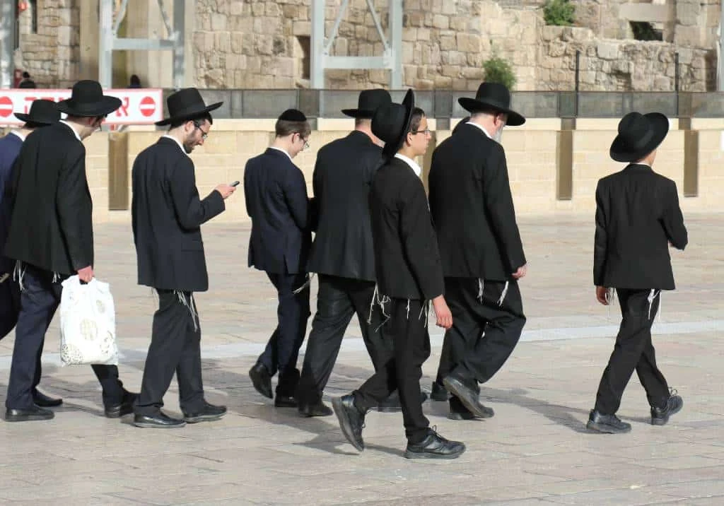 אנשים בסביבה עירונית מביטים בטלפון, המחשה לשיווק דיגיטלי המותאם לקהל החרדי